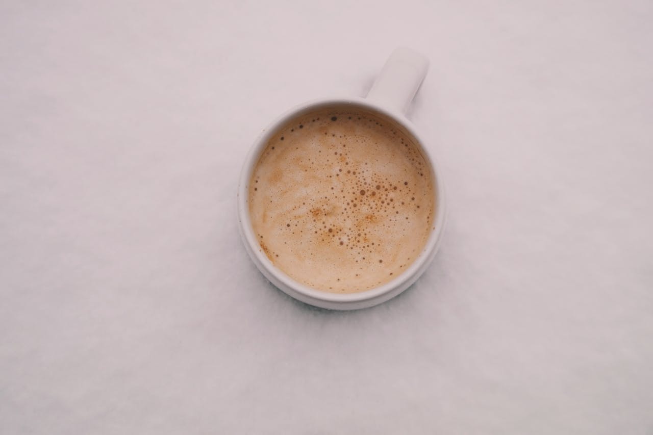 Aerial view of a creamy cappuccino in a white mug, creating a calming coffee moment.